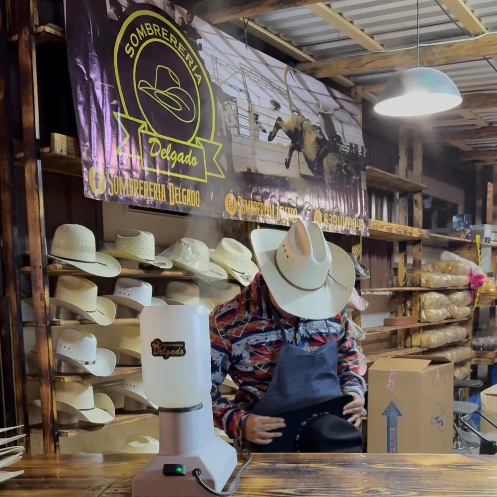 Sombrero texana siendo moldeado a vapor frente a la vaporera de la tienda